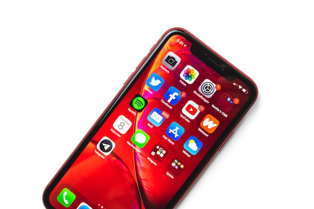 A smartphone glows with a page full of app icons.